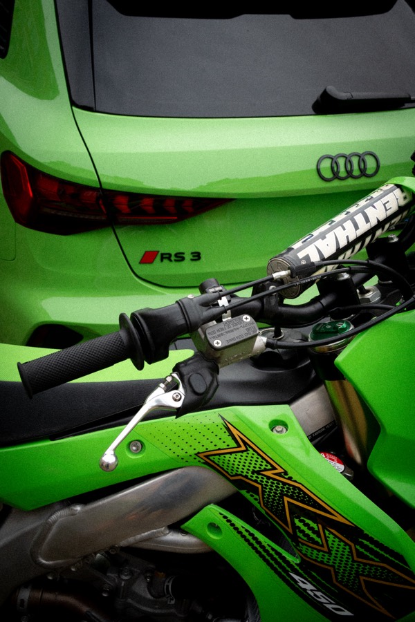 KX450 handlebar and shroud against a green car