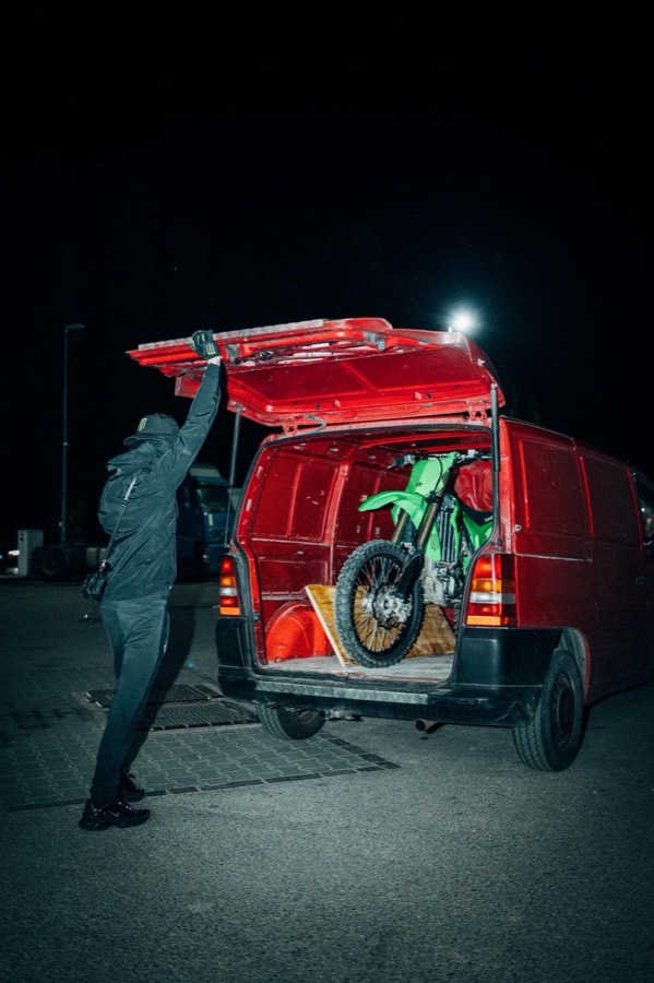 Loading the KX450 into a red van at night